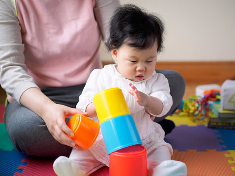 Asian Baby Girl Playing Stacking Cups