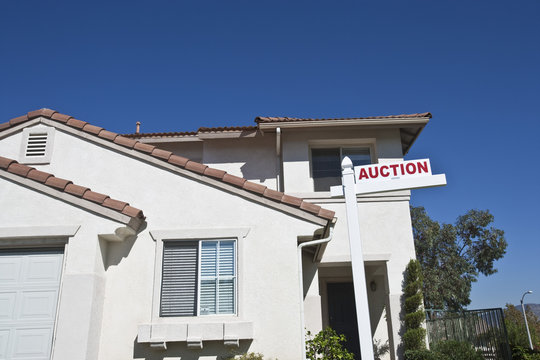 Residential structure with 'Auction Sign' against sky