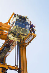 Operator having a break on gantry of mobile crane against clear sky at Limassol Cyprus