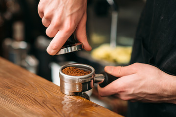 Closeup of male hands making coffee.