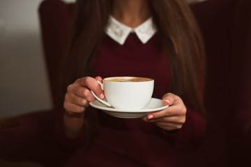 Closeup female hands holding a cup of coffee.