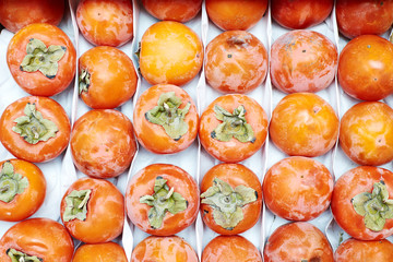 Yellow ripe persimmons in the box. Flat lay.