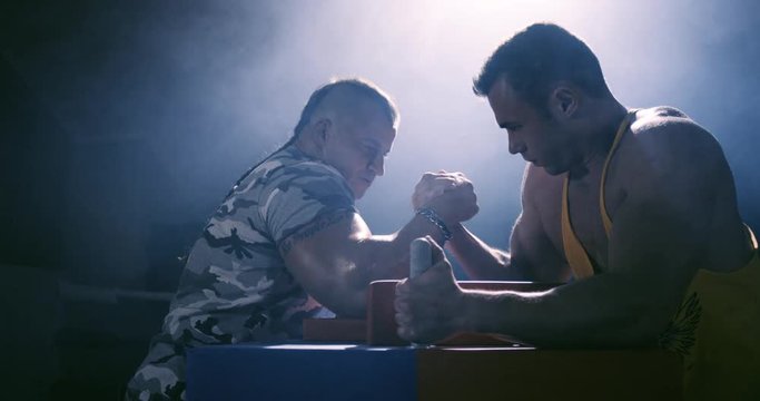 Two strong mans armwrestling in atheletic common-room