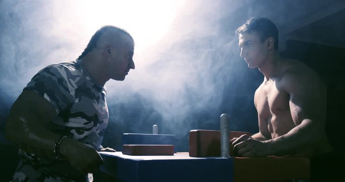 Two strong mans armwrestling in atheletic common-room