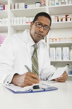 Portrait Of African American Male Pharmacist Working In Pharmacy