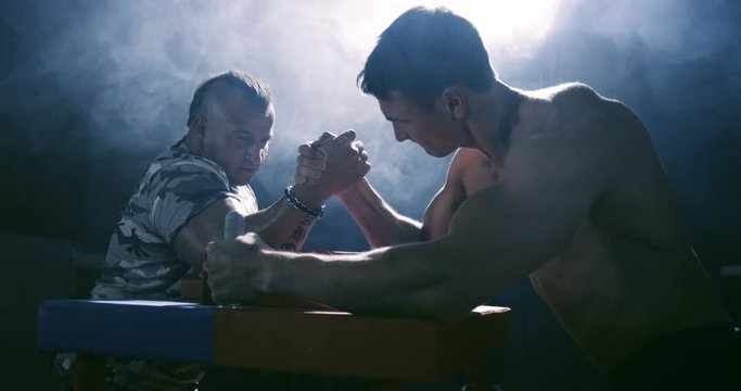 Two strong mans armwrestling in atheletic common-room