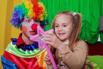 Girl playing with cheerful clown