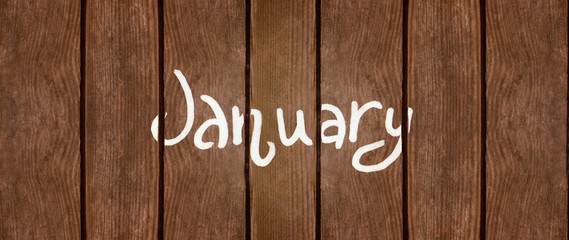 Month January. It is written in chalk on the wooden texture. View from above.