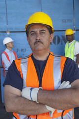 Portrait of confident middle-aged man with colleagues in background