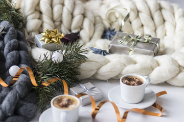 Obraz na płótnie Canvas Christmas decorations and gifts with two cups of coffee and chunky knit blankets