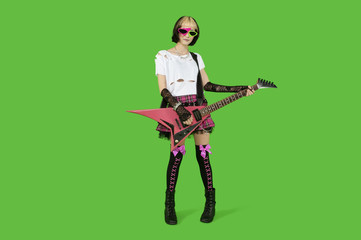 Punk woman with guitar over green colored background