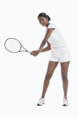 Portrait of young woman with tennis racket standing over white background