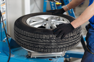 Mechanic removes car tire closeup. Machine for removing rubber from the wheel disc