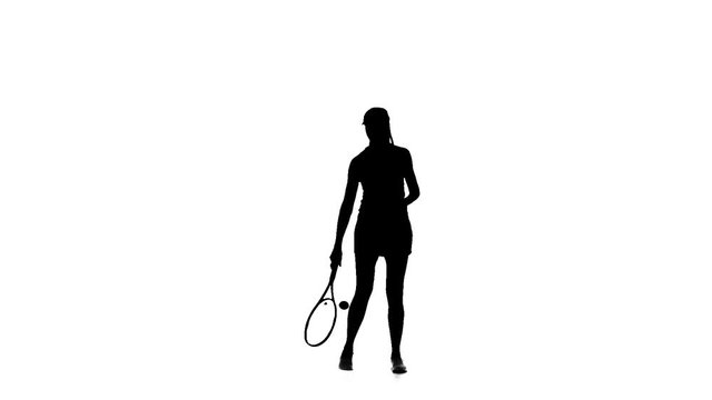 Girl playing tennis throws the ball foot and lifts it up a racket. Slow motion