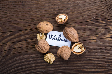 Walnut kernels and whole walnuts on old wooden table