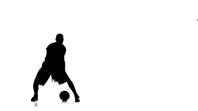Basketball player fills the ball throws it forward. Silhouette. Slow motion
