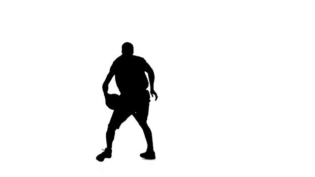 Basketball spinning in a circle and passed the ball to himself. Silhouette