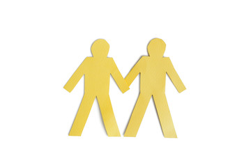 Two yellow paper cut out figures holding hands over white background