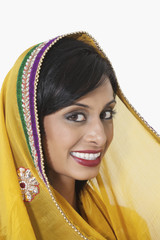 Close-up portrait of Indian woman with yellow dupatta over white background