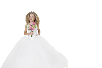 Fototapeta na wymiar Girl in wedding dress holding flower bouquet while looking away over white background