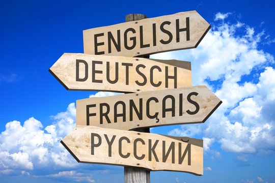 Wooden signpost with four arrows - english, german, french, russian - great for topics like multilingual, international etc.