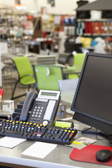 Computer with landline phone in store counter