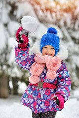 Little happy girl play snowballs