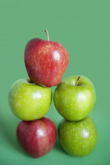 Pile of red and green apples over colored background
