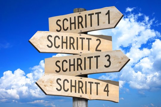 Schritt 1, Schritt 2, Schritt 3, Schritt 4 - German/ Step 1, Step 2, Step 3, Step 4 - English - wooden signpost