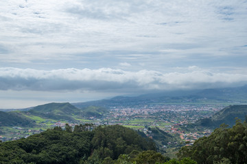Naklejka premium Green valley with village, hills and ocean background