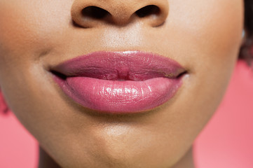 Close-up view of an African American woman's lips over colored background