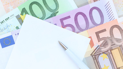 Euros, carnet de notes et stylo