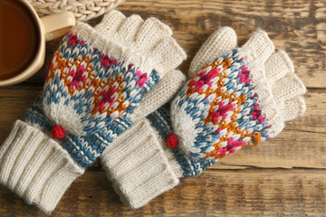 Fototapeta na wymiar Knitted mittens on wooden background
