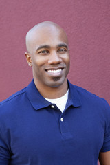 Obraz premium Portrait of a happy bald African American male over colored background