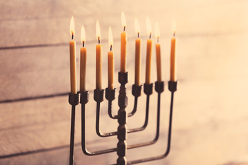 Menorah with candles for Hanukkah on blurred wooden background, close up