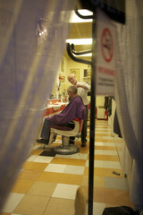 Barber giving a haircut to senior man in salon