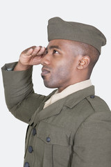 Male US soldier saluting over gray background