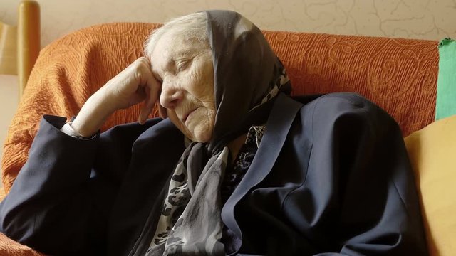depressed and desperate old woman sitting alone in her house