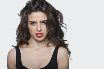 Fototapeta premium Portrait of a frustrated young female against gray background