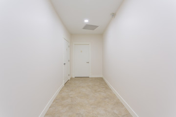 White hallway with doors in a fresh painted building.