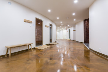 Modern sauna or spa interior with passages to steam rooms, wooden benches for relaxation, great amenities.