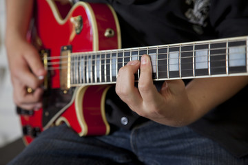 Close-up of young woman's hand playing guitar