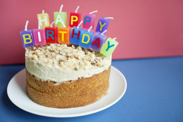 Close-up of birthday candles on torte cake over colored background