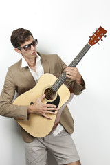 Obraz premium Young man smoking while playing guitar against white background