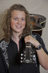 Fototapeta na wymiar Portrait of smiling young musician with guitar