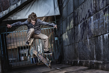 Jumping skateboarder on urban background - obrazy, fototapety, plakaty