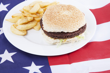 Cropped shot of chips and burger over America flag
