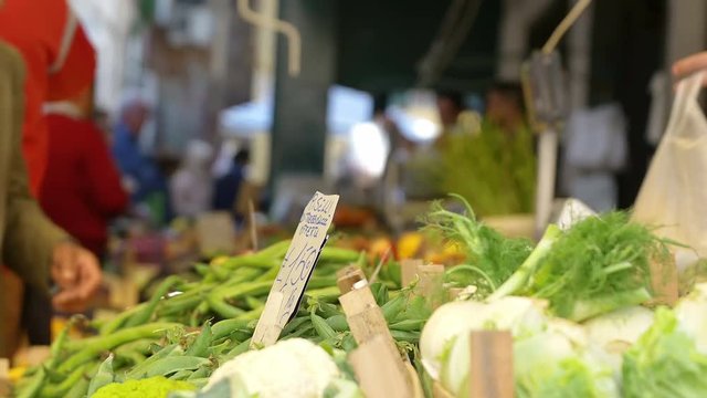 people making shopping at the open-air market: buying vegetables