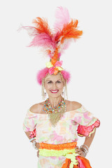 Portrait of happy senior woman in Brazilian outfit over gray background