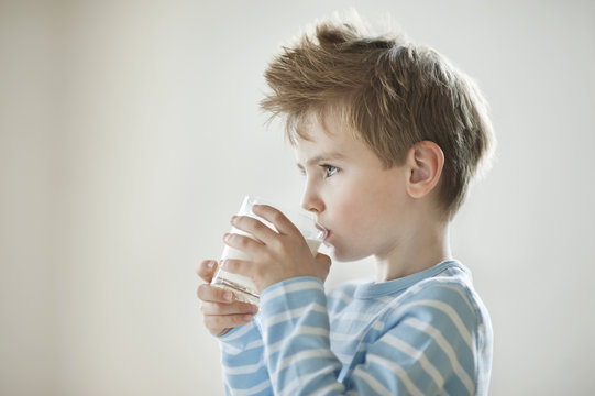 Side View Of A Young Boy Drinking Milk